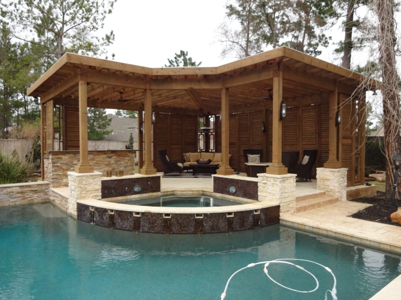 A pool with a gazebo and a hot tub in it.