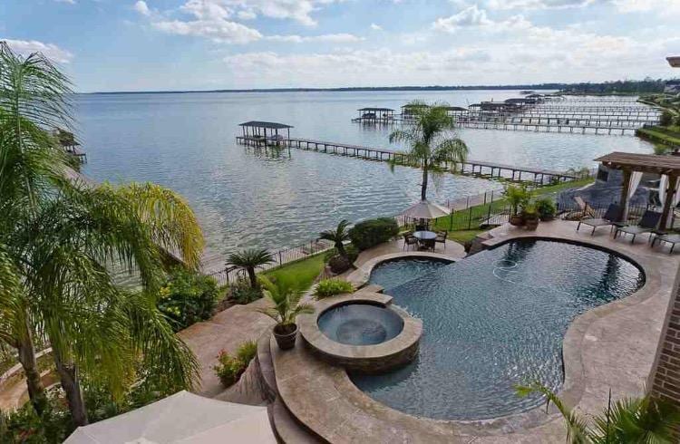 A pool with a view of the water and dock.