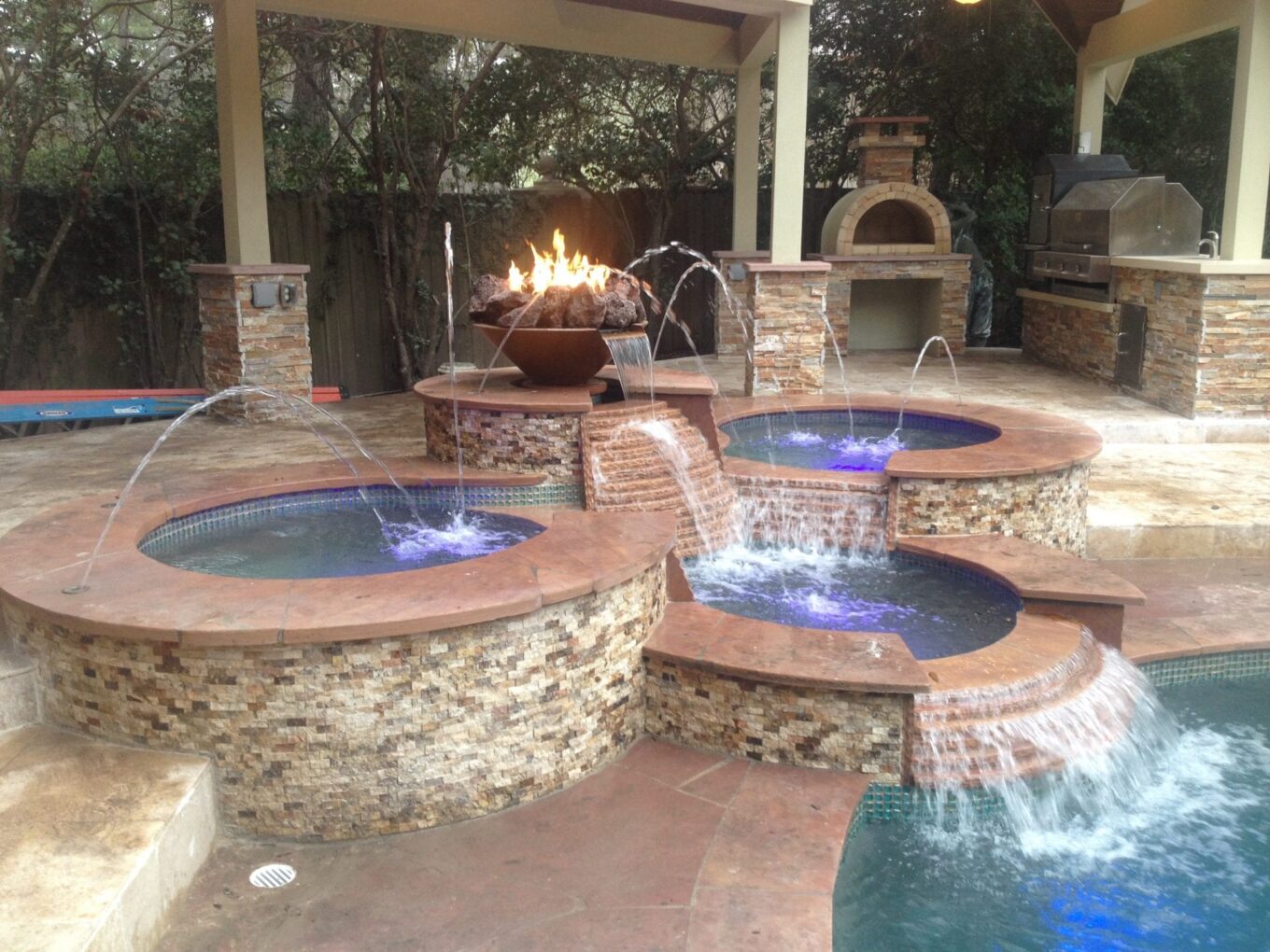 A fire pit with several fountains in the middle of it.