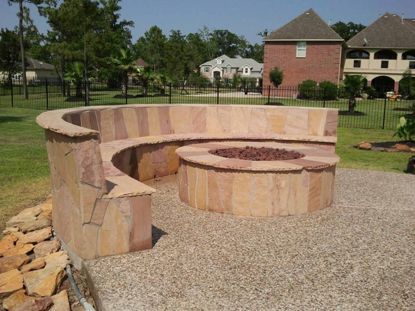 A fire pit sitting in the middle of a gravel area.