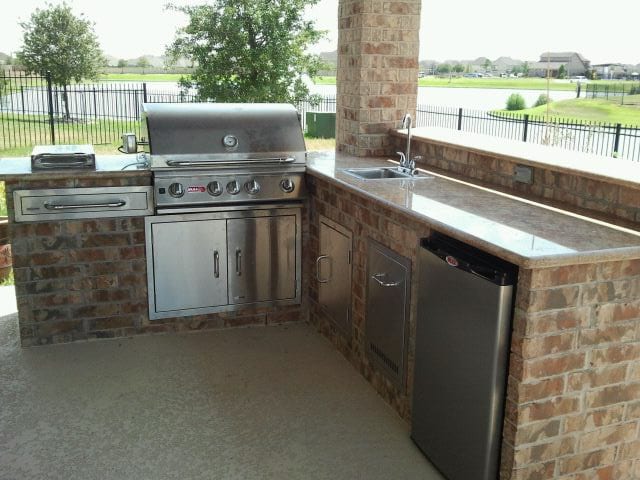 A large outdoor kitchen with an oven and sink.