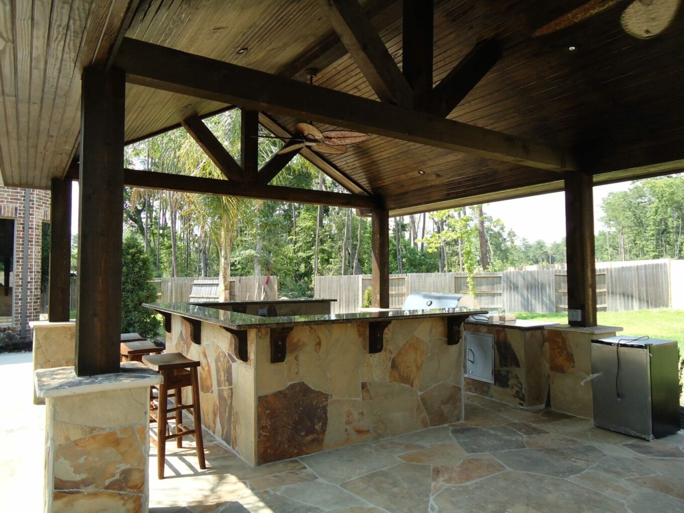 A stone outdoor kitchen with an open roof.