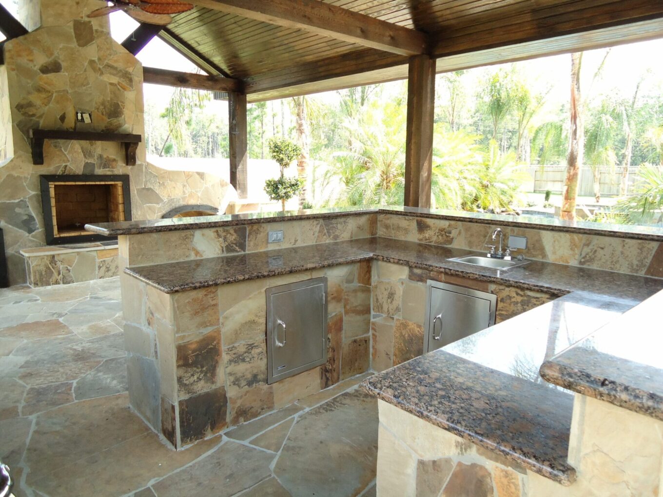 A stone kitchen with a fireplace and a large open area.