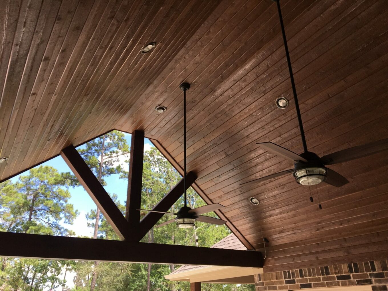 A ceiling with lights and fans in the middle of an outdoor room.