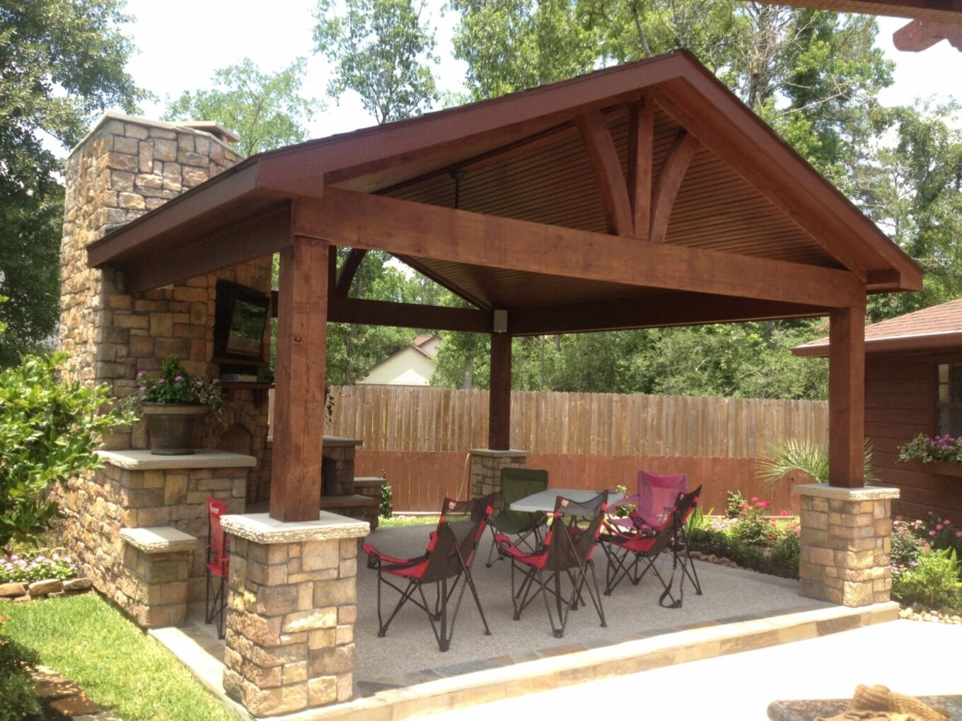 A covered patio with chairs and tables in it.
