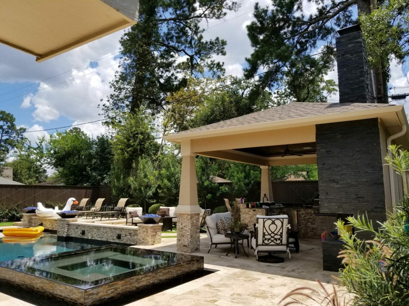 A patio with a fire pit and a large covered area.