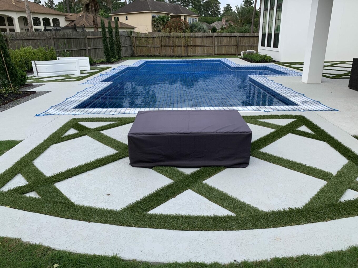 A pool with grass around it and a bench in the middle.