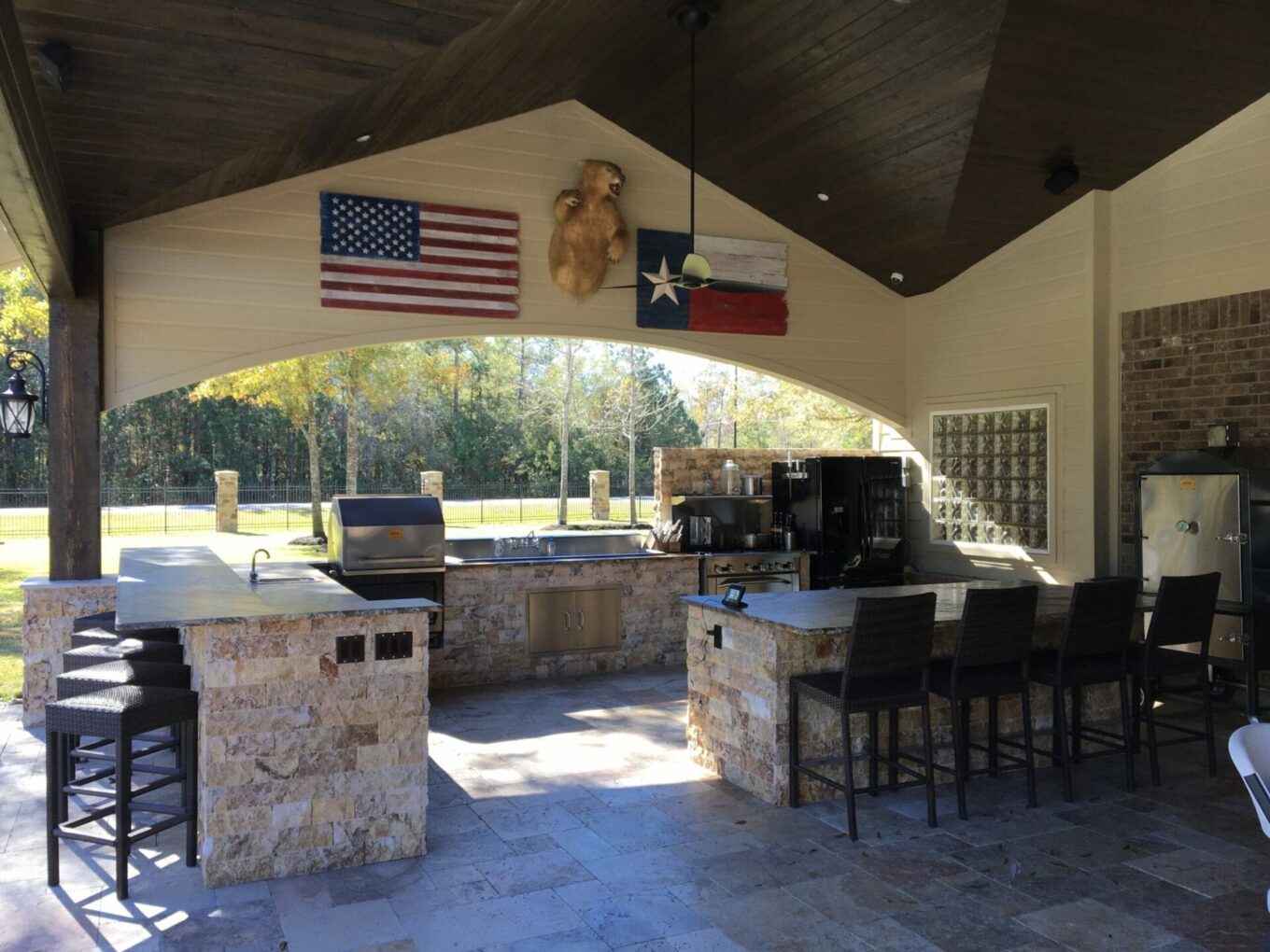 A large outdoor grill area with an american flag hanging from the ceiling.
