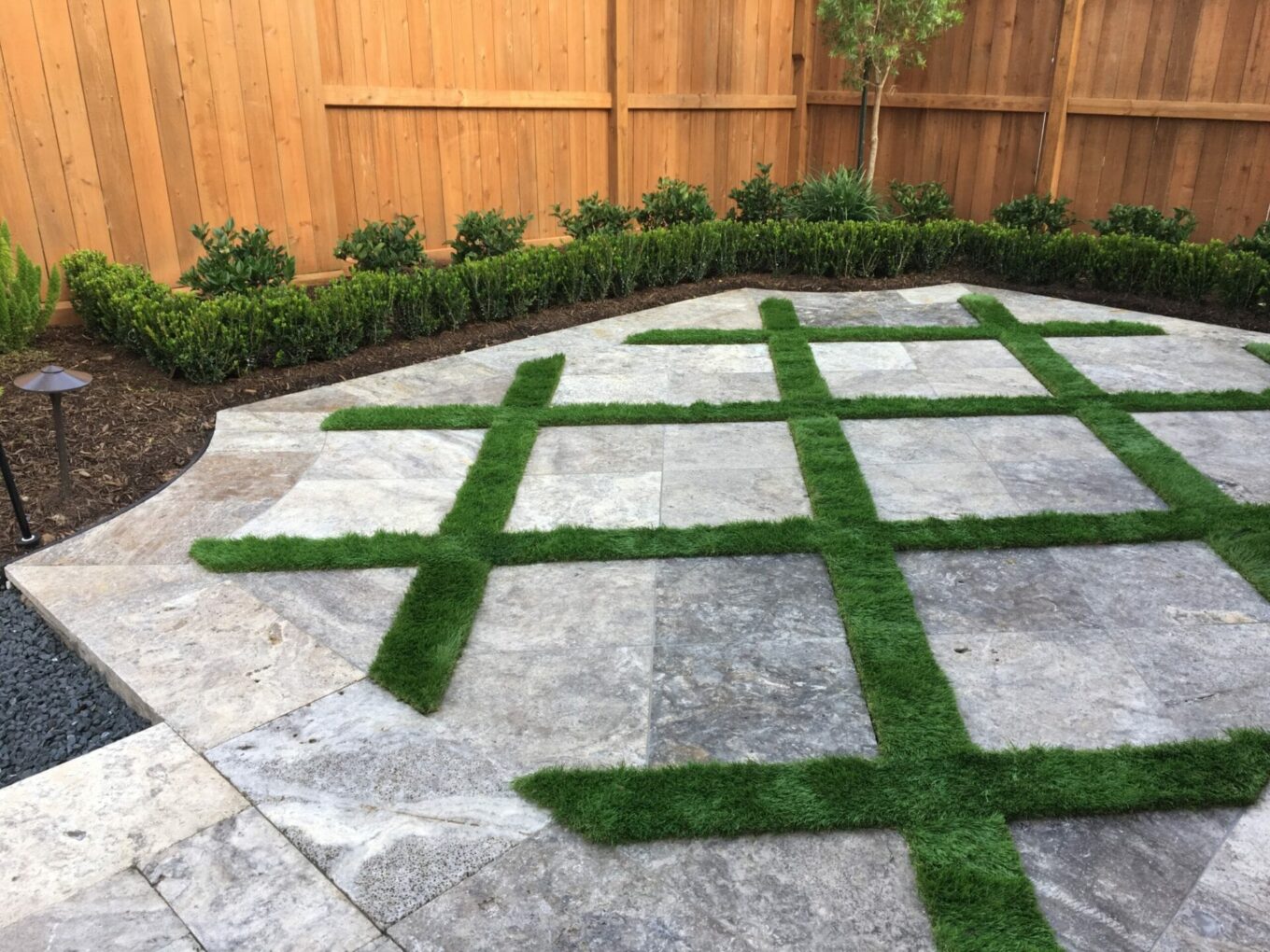 A patio with grass on the ground and concrete