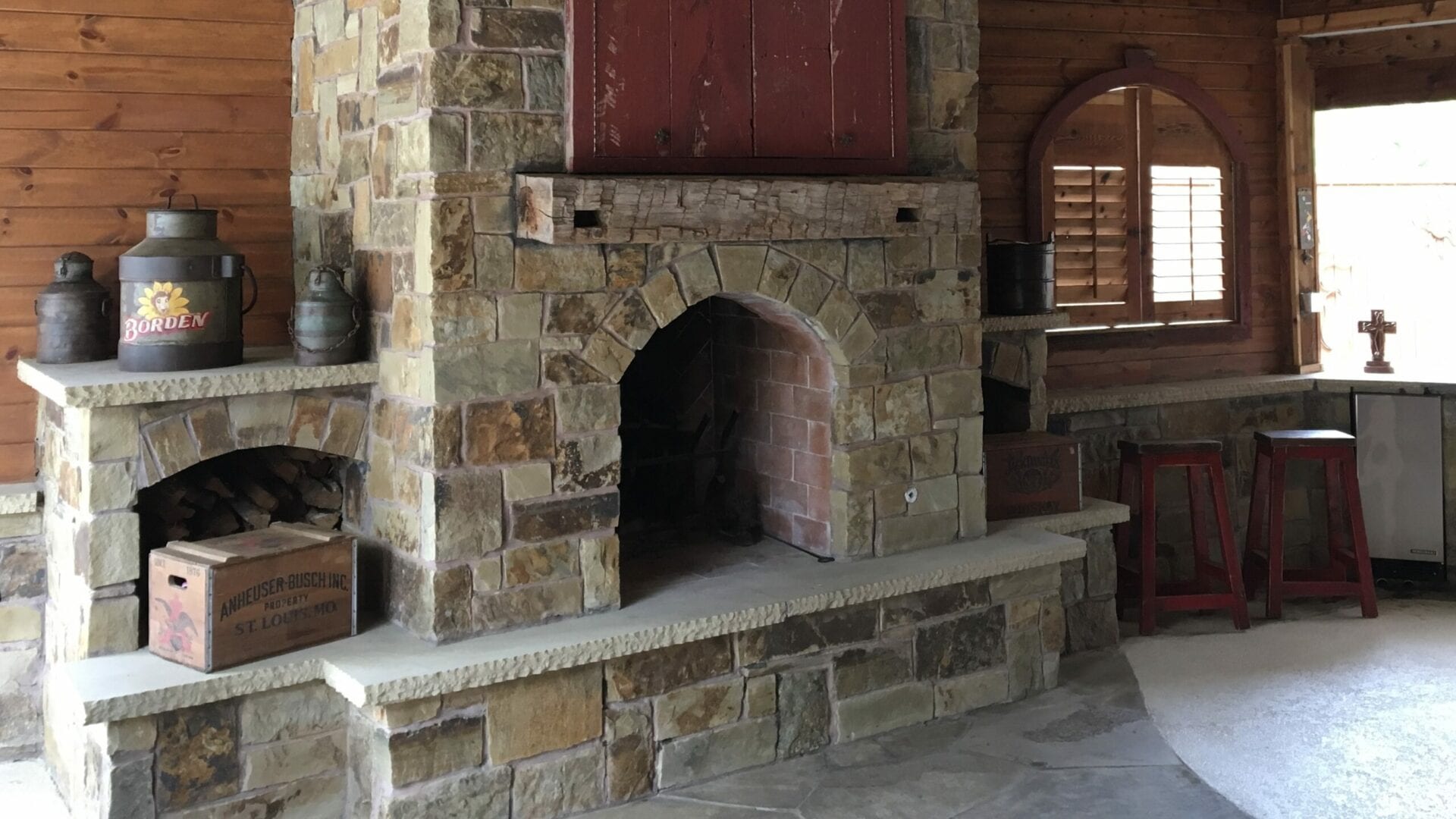 A stone fireplace with a red door in the middle.