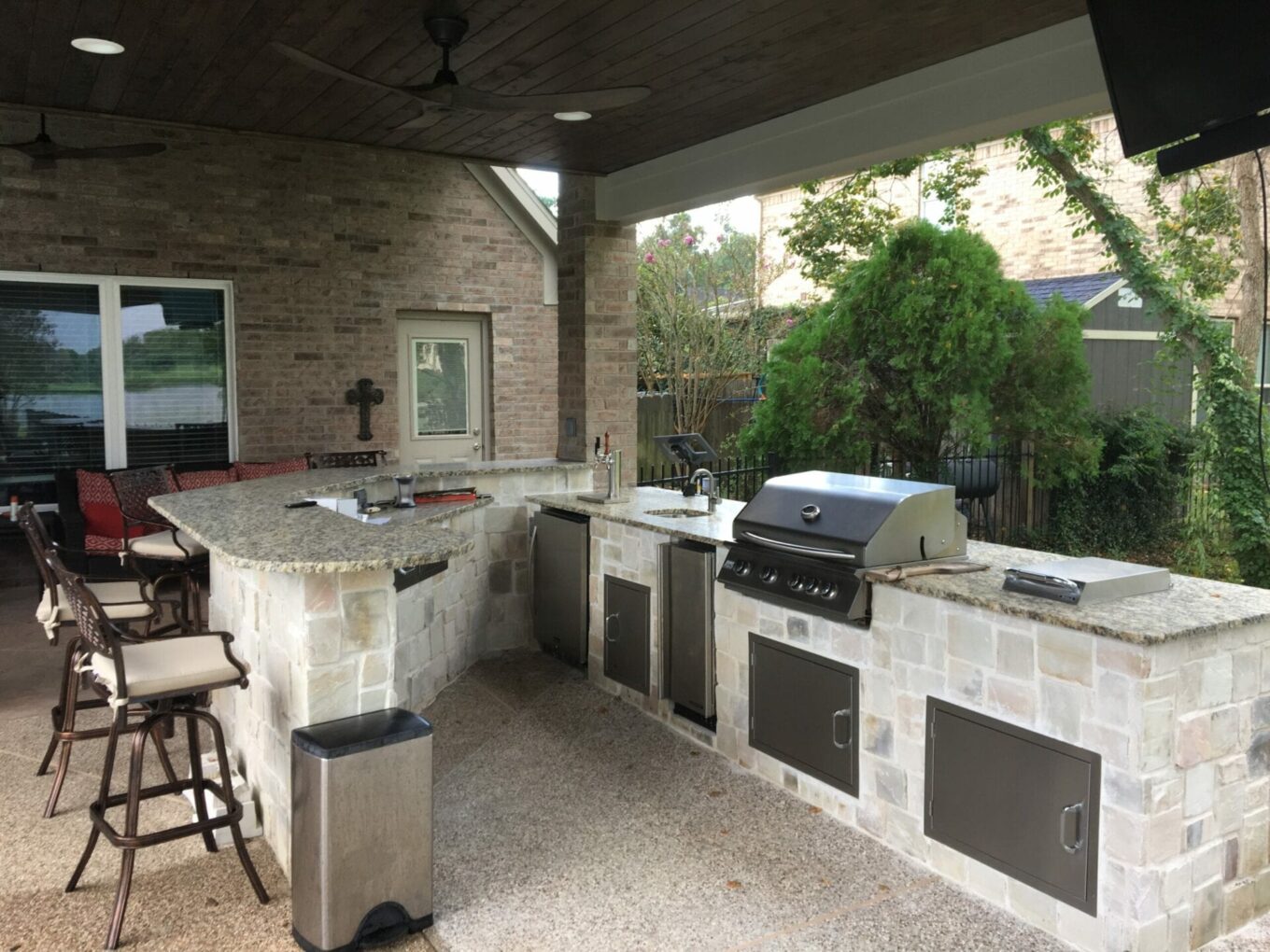 A large outdoor kitchen with an island and grill.