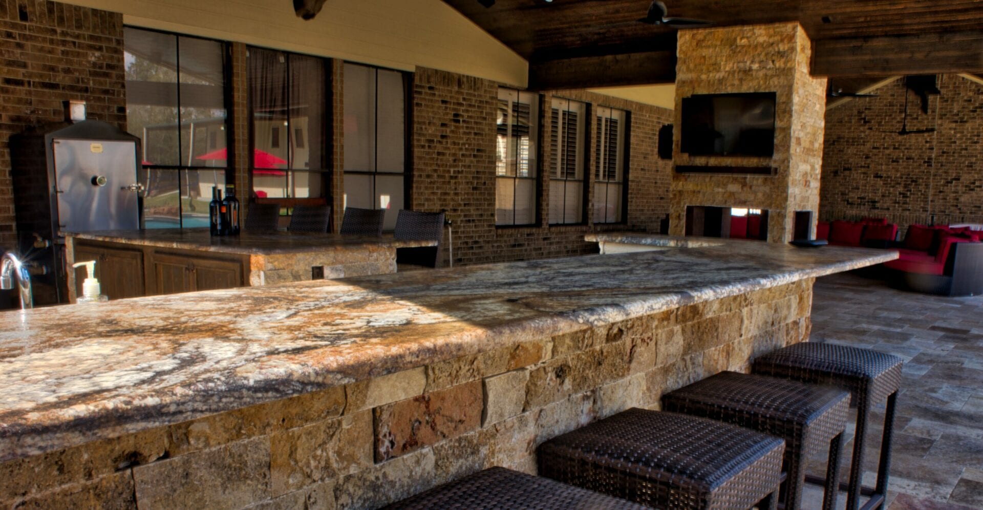 A stone bar with seating and television in the background.