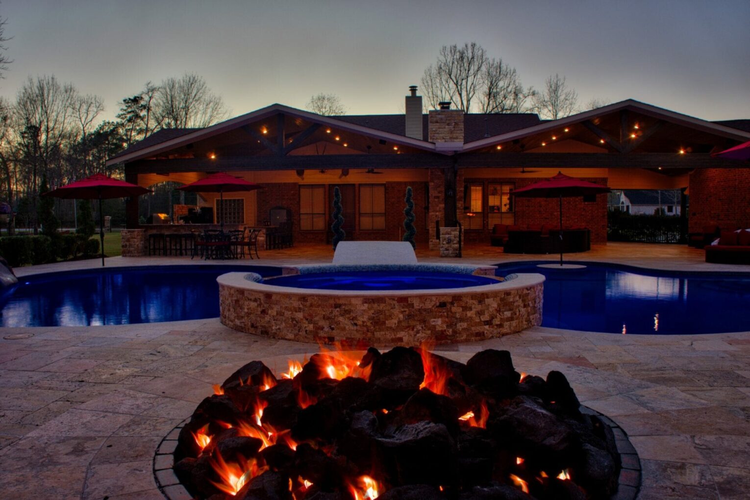 A fire pit in the middle of an outdoor pool.