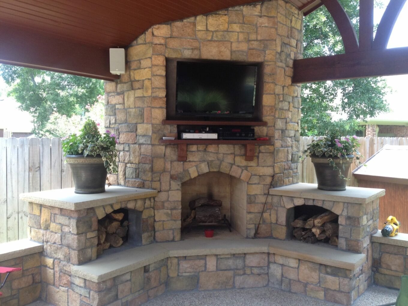 A stone fireplace with a tv mounted on the wall.