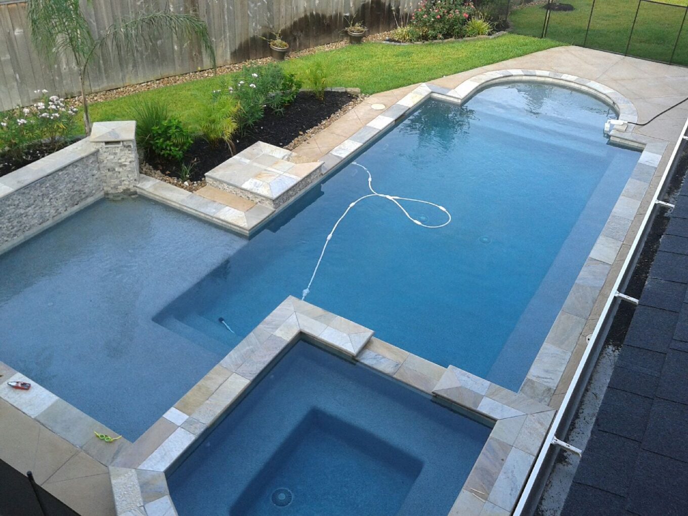 A pool with a hot tub and a diving board.