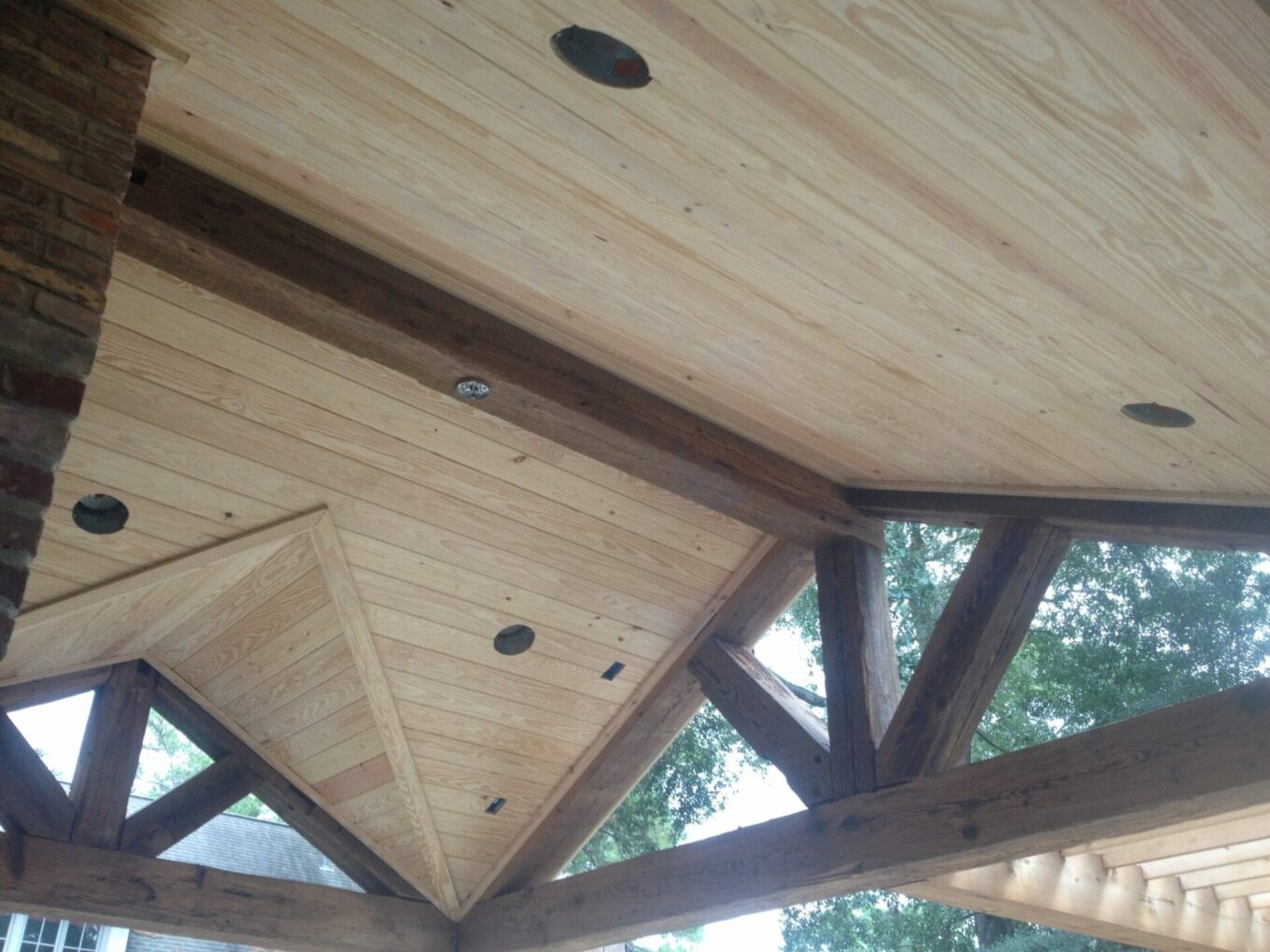 A wooden structure with beams and wood ceiling.