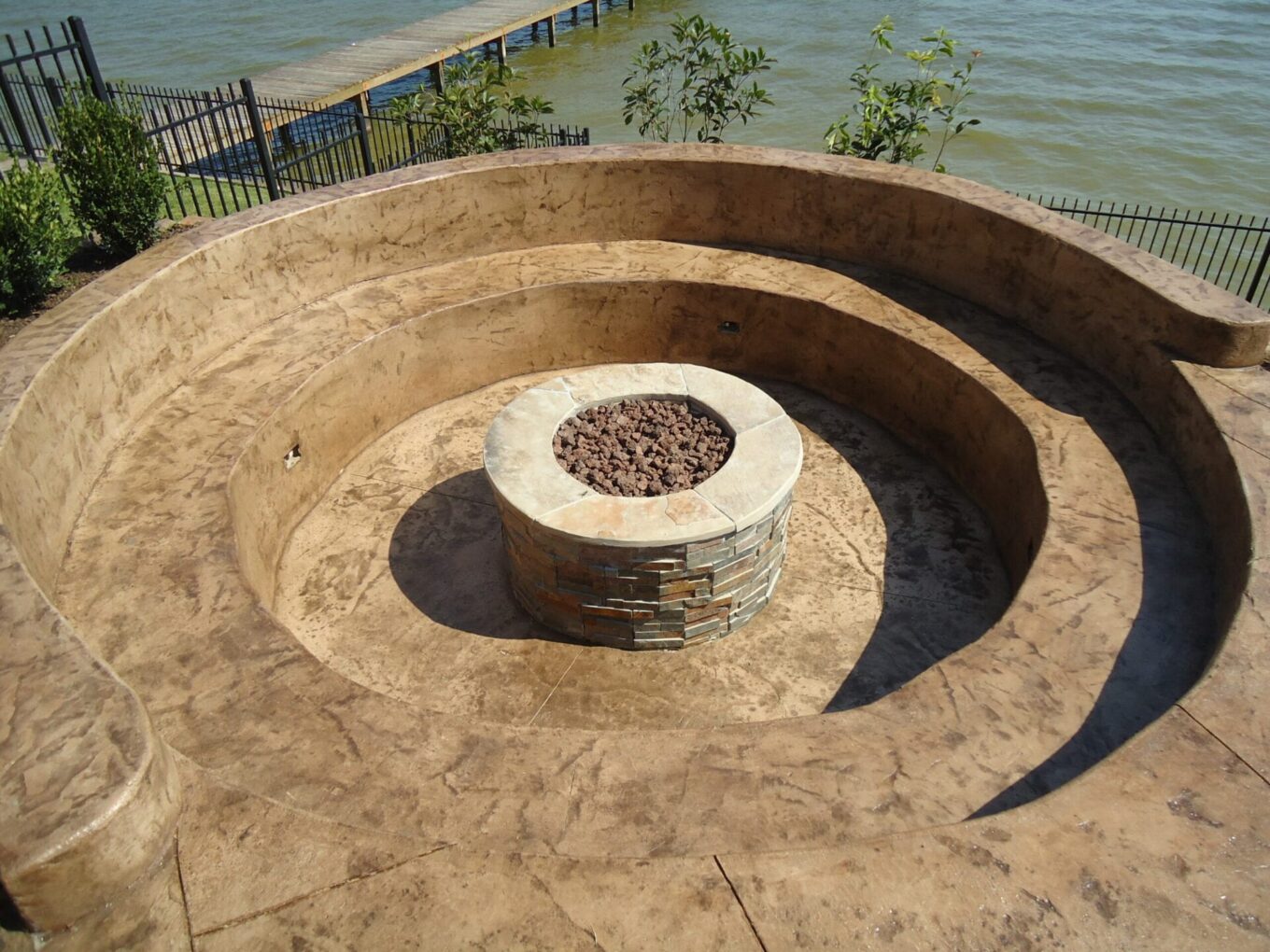 A fire pit sitting next to the water.