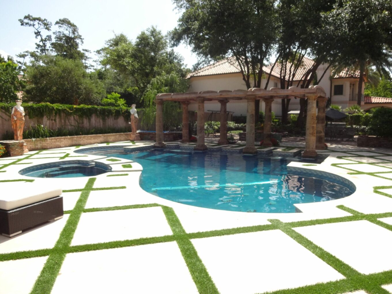 A pool with grass around it and trees in the background.