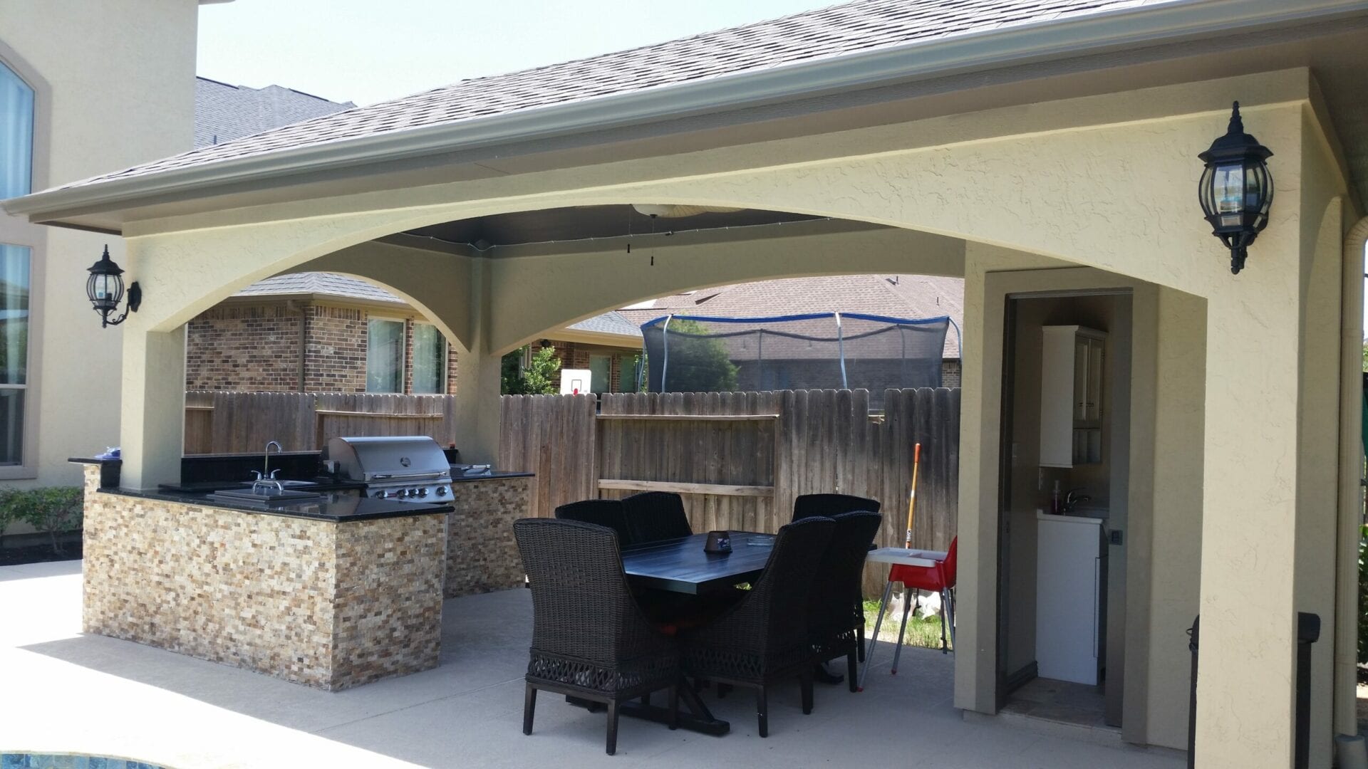 A patio with an outdoor grill and table.