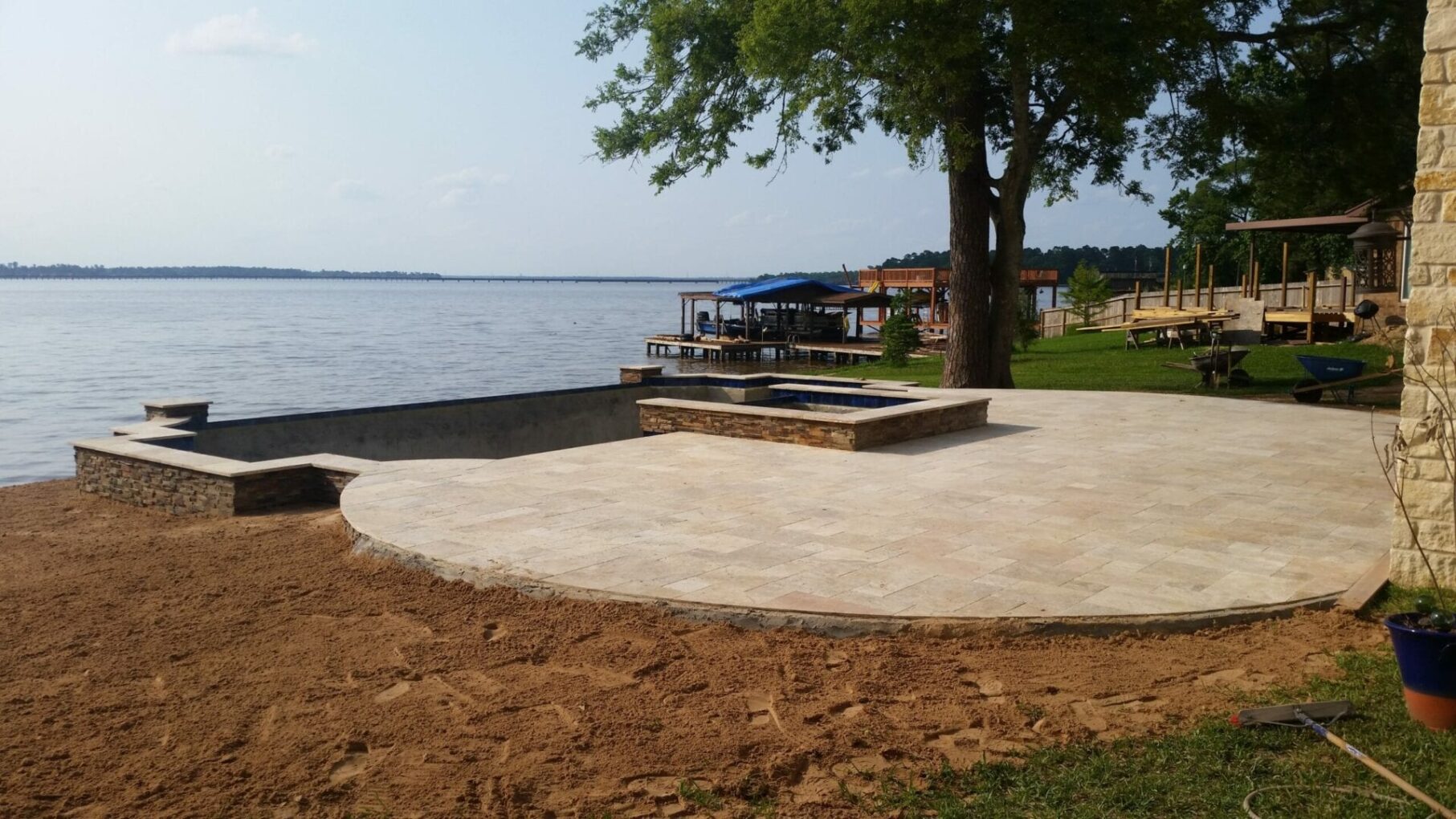 A large stone patio next to the water.