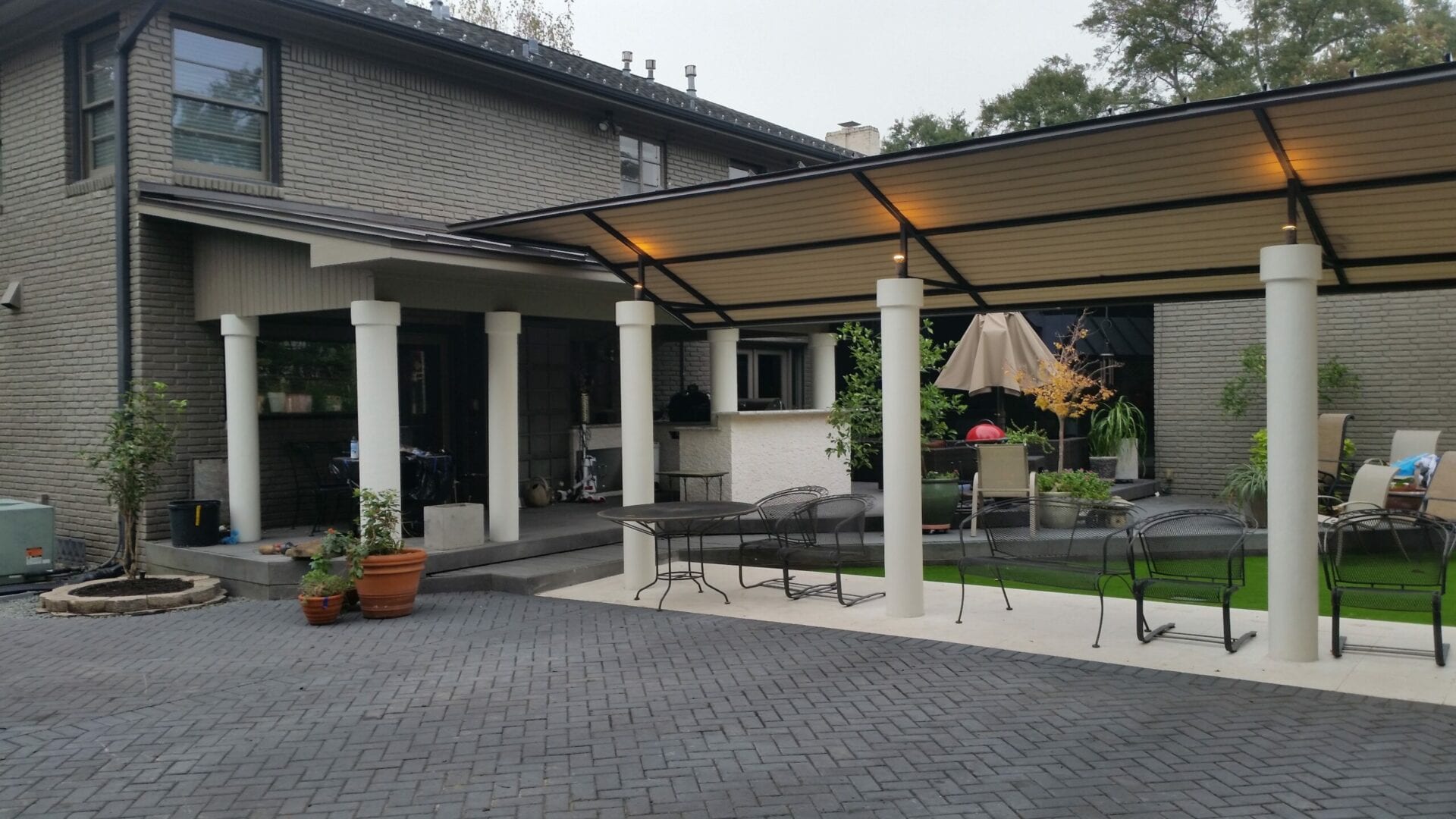 A patio with an umbrella and a grill