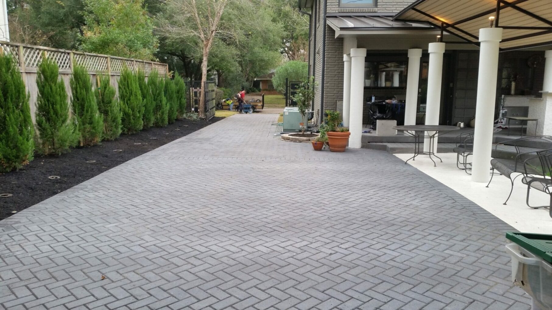 A driveway with brick and stone pavers in the middle of it.