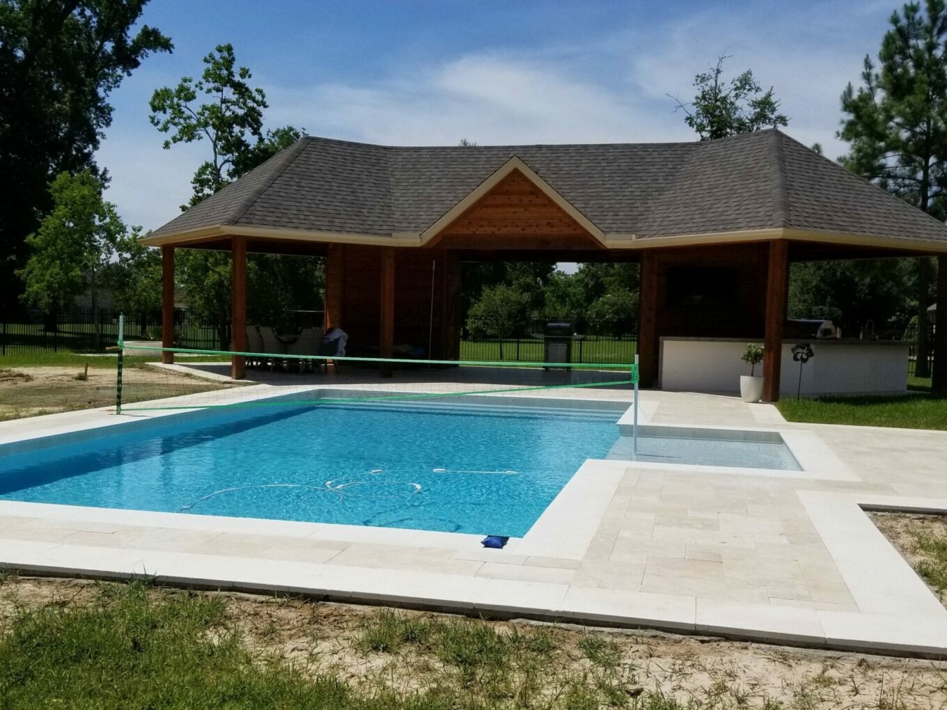 A pool with a wooden roof and a gazebo