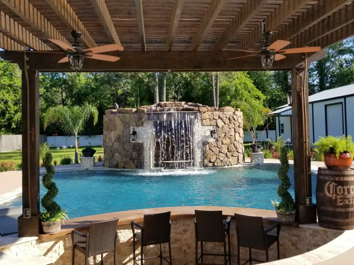 A pool with a waterfall and some chairs